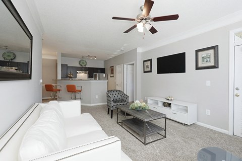 a living room with a white couch and a ceiling fan